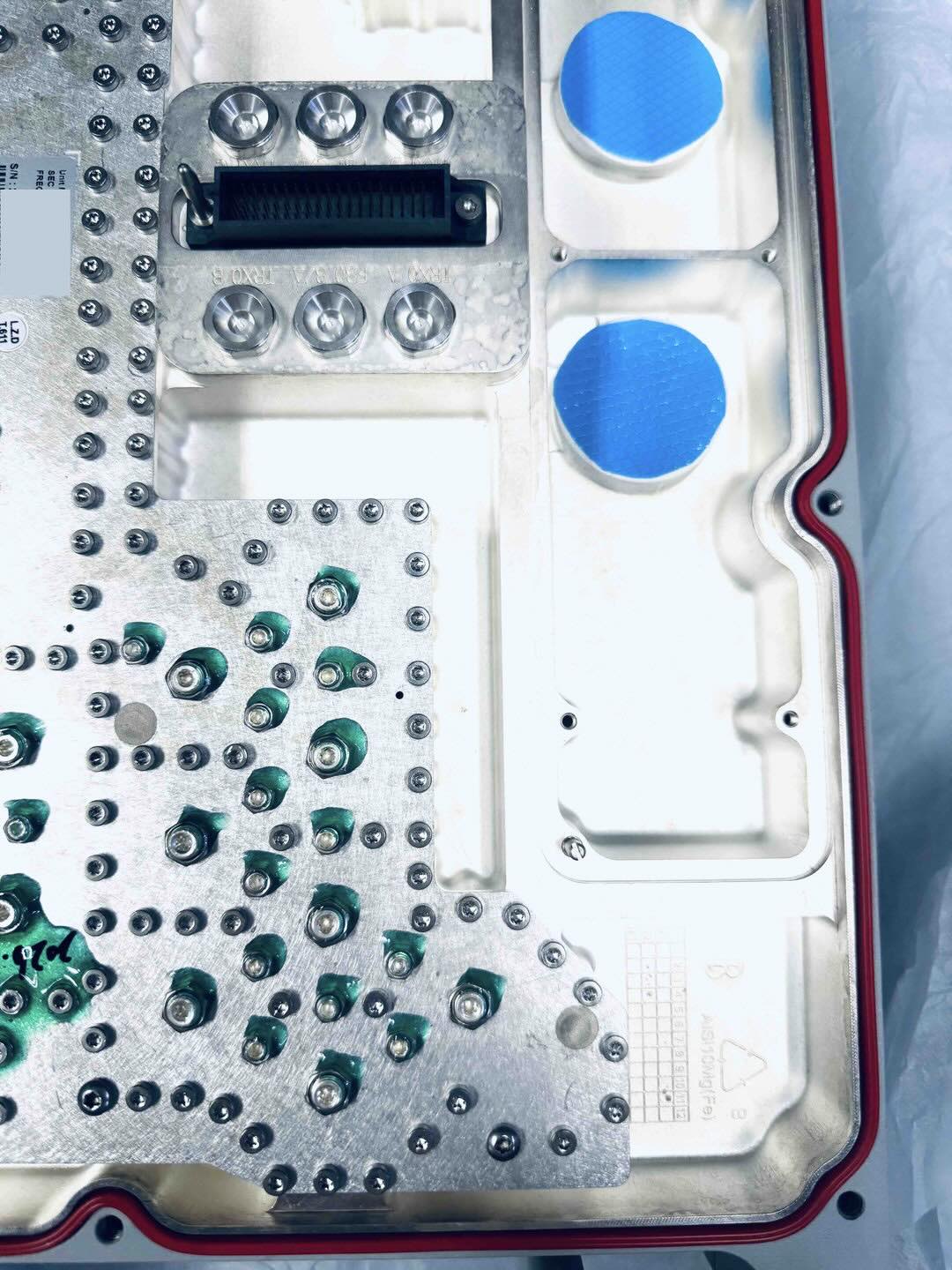 Top view of an IP67 rugged CNC enclosure featuring blue thermal pads and red waterproof O-rings for optimal DFM and heat dissipation